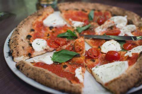 Homemade Margherita pizza with fresh mozzarella, basil leaves, and golden crust baked in oven
